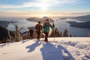Mnt Harvey, Kuzey Vancouver, Bc, Kanada - 20 Ocak 2019: maceracı arkadaş canlı kış günbatımı sırasında bir dağın tepesine hiking.