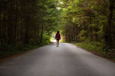 Doğal orman yolu üzerinde bir canlı yaz gündüz yürüyen kadın. Florencia Bay, Ucluelet ve Estevan, Vancouver Adası, Bc, Kanada çekilmiş.