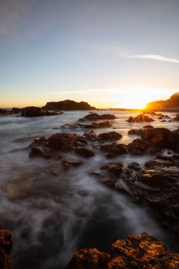 Bir canlı yaz gün batımı sırasında Pasifik Okyanusu kıyısında güzel kayalık deniz manzarası. Alınan Hecht Beach, Kuzey Vancouver Adası, Bc, Kanada.