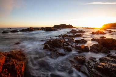 Bir canlı yaz gün batımı sırasında Pasifik Okyanusu kıyısında güzel kayalık deniz manzarası. Alınan Hecht Beach, Kuzey Vancouver Adası, Bc, Kanada.