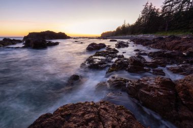 Bir canlı yaz gün batımı sırasında Pasifik Okyanusu kıyısında güzel kayalık deniz manzarası. Alınan Hecht Beach, Kuzey Vancouver Adası, Bc, Kanada.