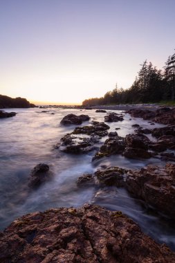 Bir canlı yaz gün batımı sırasında Pasifik Okyanusu kıyısında güzel kayalık deniz manzarası. Alınan Hecht Beach, Kuzey Vancouver Adası, Bc, Kanada.