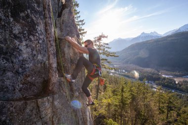 Uçurumun kenarında bir güneşli kış günbatımı sırasında erkek Rock Tırmanma. Alan 44 Squamish ve Whistler, Kuzey Vancouver, Bc, Kanada yakın çekilmiş.