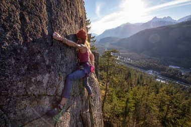 Squamish, Bc, Kanada - 15 Ocak 2019: uçurumun kenarında bir güneşli kış günbatımı sırasında kadın Rock tırmanma.