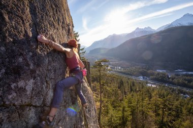 Squamish, Bc, Kanada - 15 Ocak 2019: uçurumun kenarında bir güneşli kış günbatımı sırasında kadın Rock tırmanma.