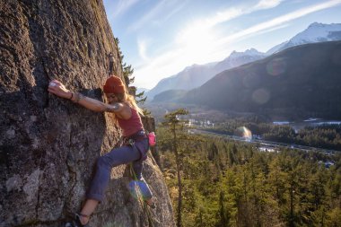 Squamish, Bc, Kanada - 15 Ocak 2019: uçurumun kenarında bir güneşli kış günbatımı sırasında kadın Rock tırmanma.