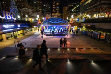 Downtown Vancouver, British Columbia, Canada - December 31, 2018: Crowd of people are ice skating in Robson Square during New Year's Eve. clipart