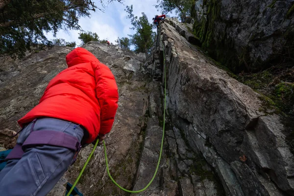 当她的搭档在悬崖边攀爬时 攀岩者在拖延时间 拍摄于加拿大 温哥华北部 Squamish Whistler 附近的第44区 — 图库照片