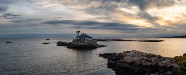 Panoramik deniz manzarası görünümü canlı bir gün batımı sırasında kayalık bir adada güzel bir ev. New Haven, Connecticut, Amerika Birleşik Devletleri'Atlantik Okyanusu üzerinde gerçekleştirilen.