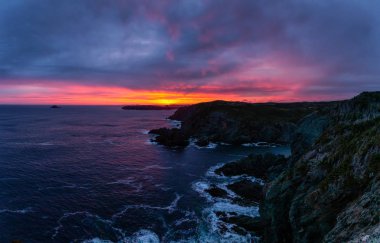 Striking seascape view on a rocky Atlantic Ocean Coast during a colorful sunrise. Taken at Crow Head, North Twillingate Island, Newfoundland and Labrador, Canada. clipart