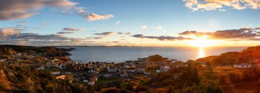 Panoramic view of a small town on the Atlantic Ocean Coast during a vibrant sunset. Taken in Crow Head, North Twillingate Island, Newfoundland and Labrador, Canada. clipart