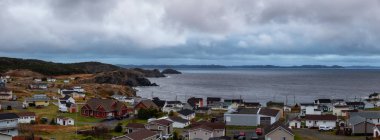 Panoramic view of a small town on the Atlantic Ocean Coast during a cloudy evening. Taken in Crow Head, North Twillingate Island, Newfoundland and Labrador, Canada. clipart
