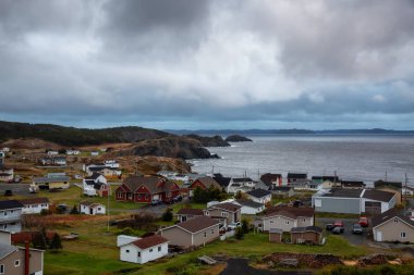 Beautiful view of a small town on the Atlantic Ocean Coast during a cloudy evening. Taken in Crow Head, North Twillingate Island, Newfoundland and Labrador, Canada. clipart