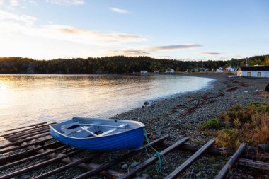 Ahşap tekne tarafından Atlantik Okyanusu kıyısında canlı gün doğumu sırasında döşeme. Sahilde yer alan, alınan Newfoundland, Canada.