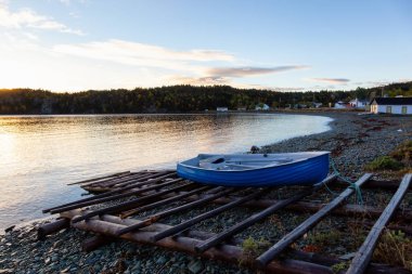 Ahşap tekne tarafından Atlantik Okyanusu kıyısında canlı gün doğumu sırasında döşeme. Sahilde yer alan, alınan Newfoundland, Canada.