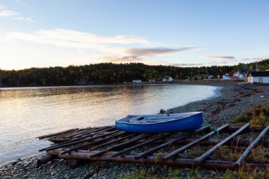 Ahşap tekne tarafından Atlantik Okyanusu kıyısında canlı gün doğumu sırasında döşeme. Sahilde yer alan, alınan Newfoundland, Canada.