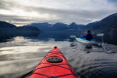 Maceracı adam huzurlu suda bir bulutlu kış gün boyunca kayak. Squamish, Vancouver, Bc, Kanada kuzeyindeki alınan.