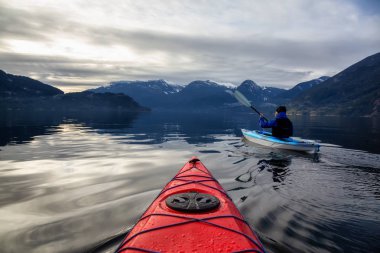 Maceracı adam huzurlu suda bir bulutlu kış gün boyunca kayak. Squamish, Vancouver, Bc, Kanada kuzeyindeki alınan.