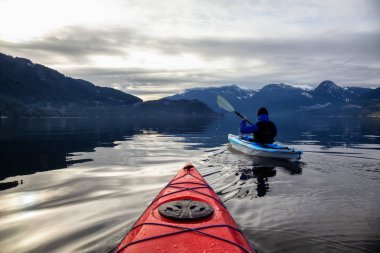 Maceracı adam huzurlu suda bir bulutlu kış gün boyunca kayak. Squamish, Vancouver, Bc, Kanada kuzeyindeki alınan.