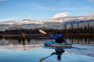 Maceracı adam huzurlu suda bir bulutlu kış gün boyunca kayak. Squamish, Vancouver, Bc, Kanada kuzeyindeki alınan.
