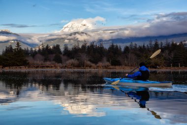 Maceracı adam huzurlu suda bir bulutlu kış gün boyunca kayak. Squamish, Vancouver, Bc, Kanada kuzeyindeki alınan.