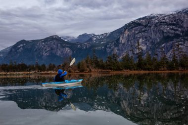 Bir bulutlu kış günbatımı sırasında huzurlu su kayağı maceracı adam. Squamish, Vancouver, Bc, Kanada kuzeyindeki alınan.