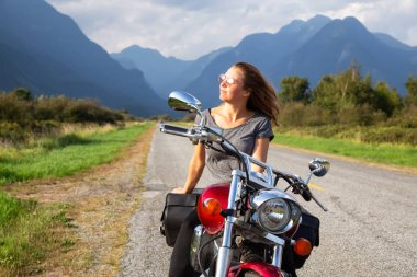 Kadın Kanada dağlarla çevrili doğal bir yol üzerinde bir motosiklet Binme. Pitt Meadows, büyük Vancouver, Bc, Kanada alınan.