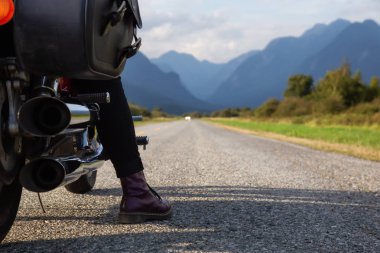 Kadın Kanada dağlarla çevrili doğal bir yol üzerinde bir motosiklet Binme. Pitt Meadows, büyük Vancouver, Bc, Kanada alınan.