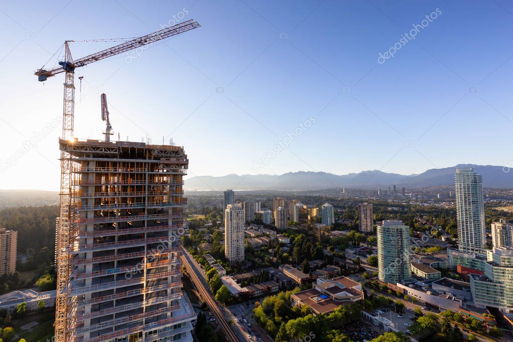 Aerial view of a residential building construction site during a vibrant summer sunset. Taken in Burnaby, Vancouver, BC, Canada.