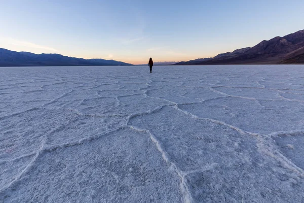 Woman walking on Salt Pan at the Badwater Basin, Death Valley National Park, California, United States.