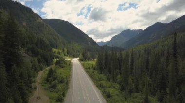 Güneşli bir yaz günü boyunca dağlar arasındaki vadide doğal bir rota havadan görünümü. 3 Numara Highway,British Columbia, Kanada.