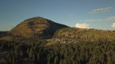 Güneşli bir yaz gün batımı sırasında bir dağın tepesinde konut evlerin havadan görünümü. Taken in Kelowna, British Columbia, Kanada.