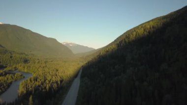 Güneşli bir yaz sabahı Güzel Kanada Dağları ile çevrili doğal bir yolun havadan görünümü. Revelstoke, British Columbia, Kanada yakınlarında çekilmiş.