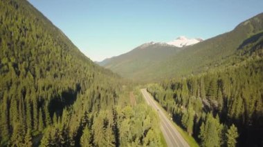 Güneşli bir yaz sabahı Güzel Kanada Dağları ile çevrili doğal bir yolun havadan görünümü. Revelstoke, British Columbia, Kanada yakınlarında çekilmiş.