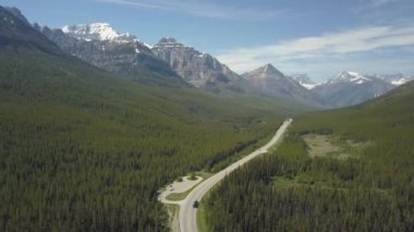 Güneşli bir yaz günü boyunca güzel Kanada Dağ Manzara ile çevrili vadide doğal bir yolun havadan görünümü. Banff, Alberta, Kanada yakınlarında çekilmiş.