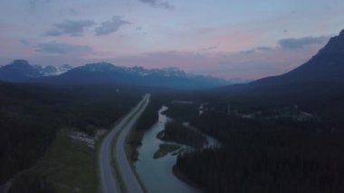 Renkli bir yaz gündoğumu sırasında güzel Kanada Dağ Manzara ile çevrili vadide doğal bir yolun havadan görünümü. Banff, Alberta, Kanada yakınlarında çekilmiş.