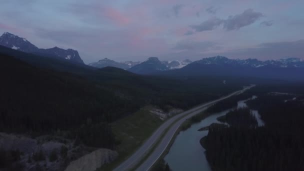 在五颜六色的夏季日出中 山谷中风景优美的道路鸟瞰图 周围环绕着美丽的加拿大山景 在加拿大阿尔伯塔省班夫附近拍摄 — 图库视频影像