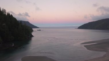 Hava bulutlu yaz gün doğumu sırasında Pasifik Okyanusu kıyısında güzel bir plaj manzarası. Alınan San Josef Bay, Kuzey Vancouver Adası, British Columbia, Kanada.