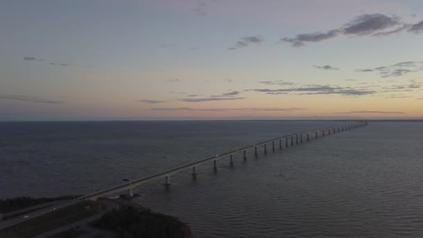 鮮やかな夕日の間にコカニュ川を渡る橋の航空写真 カナダ ニューブランズウィック州で撮影 — ストック動画