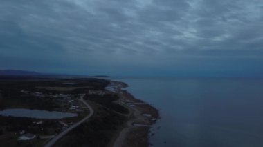 Dramatik bir bulutlu gündoğumu sırasında Atlantik Okyanusu Kıyısı yakınlarındaki doğal bir yolun havadan görünümü. Newfoundland, Kanada'da çekildi.