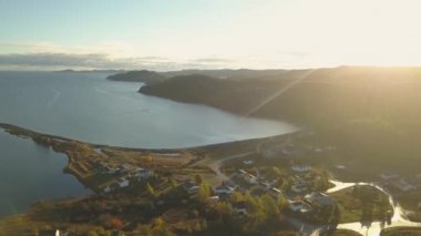 Aerial view of a small town on a rocky Atlantic Ocean Coast during a bright sunny sunrise. Taken in Little Bay, Newfoundland, Canada.