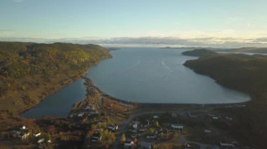 Aerial view of a small town on a rocky Atlantic Ocean Coast during a bright sunny sunrise. Taken in Little Bay, Newfoundland, Canada.