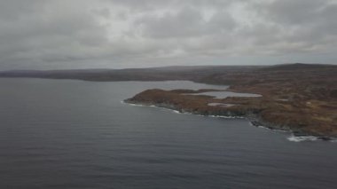 Bulutlu bir gün boyunca kayalık Bir Atlantik Okyanusu Kıyısında küçük bir kasabanın havadan görünümü. Quirpon, Newfoundland, Kanada'da alındı.