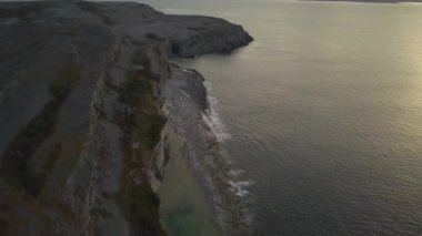 Bir bulutlu gün batımı sırasında kayalık bir Atlantik Okyanusu kıyılarının havadan görünümü. Yanmış Cape ekolojik alınan rezerv, Raleigh, Newfoundland, Canada.