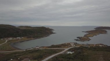 Bulutlu bir gün boyunca kayalık Bir Atlantik Okyanusu Kıyısında küçük bir kasabanın havadan görünümü. Little Quirpon, Newfoundland, Kanada'da çekildi.