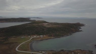 Bulutlu bir gün boyunca kayalık Bir Atlantik Okyanusu Kıyısında küçük bir kasabanın havadan görünümü. Little Quirpon, Newfoundland, Kanada'da çekildi.