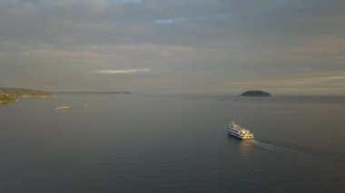 Bir feribot tekne okyanusa canlı bir bulutlu gün batımı sırasında hava görünümünü. Horseshoe Bay, Batı Vancouver, British Columbia, Kanada alınan.