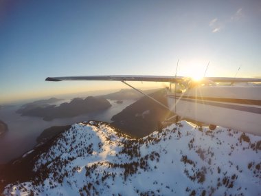 Rocky Candian Dağları yakınında canlı bir gün batımı sırasında uçan küçük uçak. Squamish Kuzey Vancouver, British Columbia, Kanada alınan.