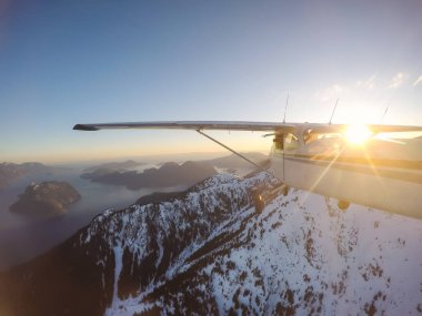 Rocky Candian Dağları yakınında canlı bir gün batımı sırasında uçan küçük uçak. Squamish Kuzey Vancouver, British Columbia, Kanada alınan.