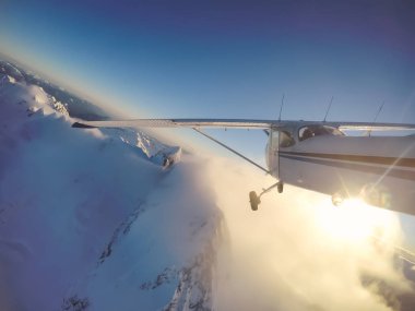 Rocky Candian Dağları yakınında canlı bir gün batımı sırasında uçan küçük uçak. Squamish Kuzey Vancouver, British Columbia, Kanada alınan.